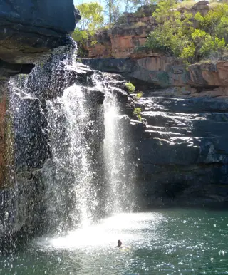 Schwimme unter einem Wasserfall